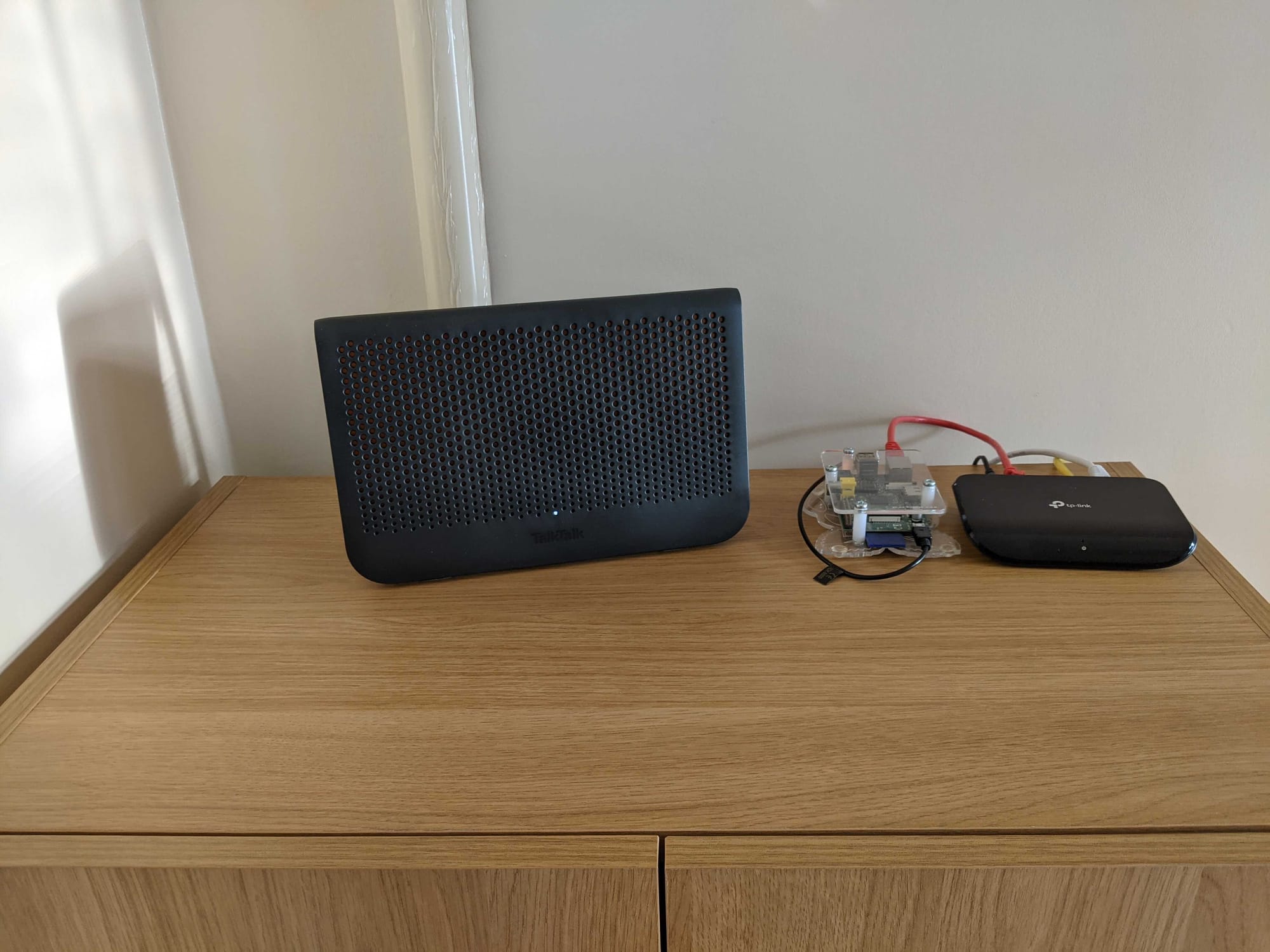 TalkTalk (UK ISP) modem/router with an entry-level TP-Link switch and an original Raspbery Pi running Pi Hole (and nothing else)